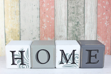 Blocks spelling Home on a distressed wood background.