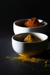 Spices in cups on a black background