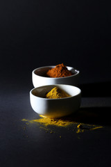 Spices in cups on a black background