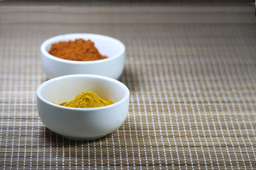 Spices in cups on a mat background