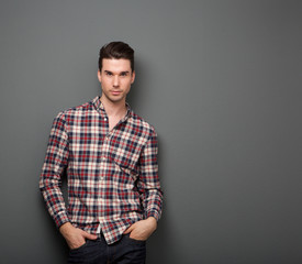 Relaxed young man with checkered shirt posing