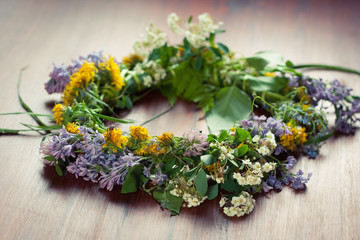Closeup of a wreath of wild spring flowers on a wooden table