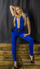 Obraz na płótnie Canvas Beautiful slim blonde in blue overalls