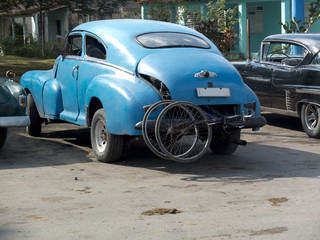 Obraz na płótnie Canvas Vieille voiture américaine transportant des vélos à Cuba.
