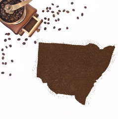 Coffee powder in the shape of New South Wales and a coffee mill.