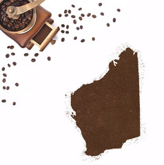 Coffee powder in the shape of Western Australia and a coffee mil