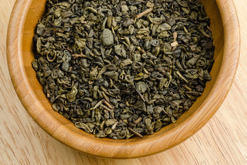green tea, dried leaves, on wooden background