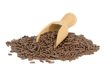 A heap of chocolate sprinkles with scoop on white background