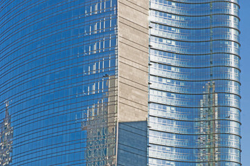 office building with glass facade and blue sky reflection