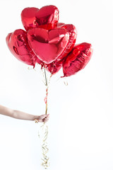 Hand with heart-shaped balloons. Valentine's day.
