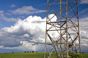 electricity high voltage metal pole  on summer farmland field