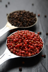 Pink and black peppercorns on a spoon