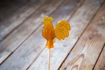 sugar lollipop rooster on wooden background