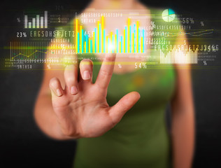 Young business woman touching colorful charts and diagrams