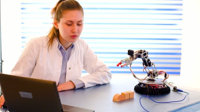 cientist adjusts the robot arm