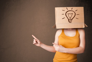 Young woman gesturing with a cardboard box on her head with ligh - obrazy, fototapety, plakaty
