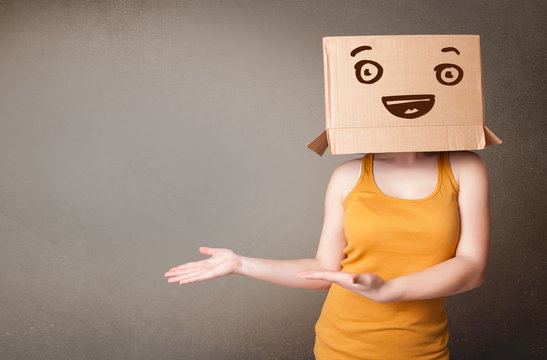 Young woman gesturing with a cardboard box on her head with smil