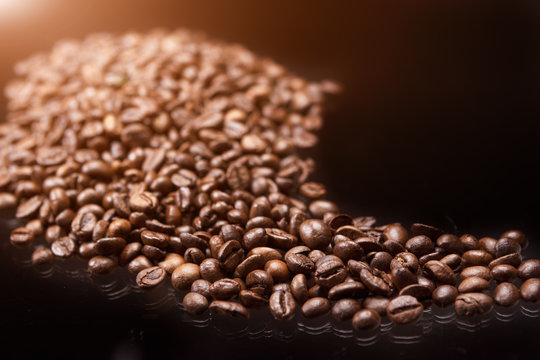 Line made of Roasted Coffee Beans Over Black Background. Light E