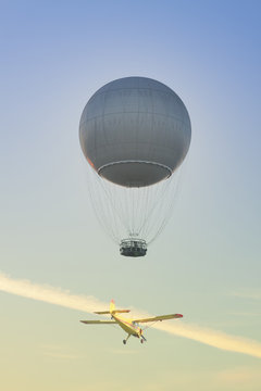 Gas Balloon and Yellow Aircraft against the Sky