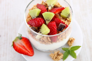 yogurt dessert with muesli and berries in small glass