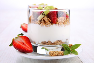 yogurt dessert with muesli and berries in small glass