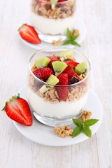 yogurt dessert with muesli and berries in small glass