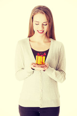 Beautiful woman holding small present in hands.