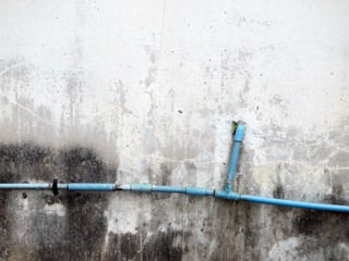 plumbing pipe against stucco wall , industrial grunge background