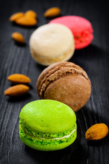 Colorful French macaroons on a dark rustic wooden background,