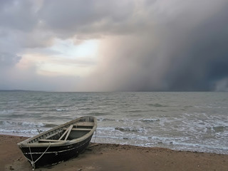 Obrazy na Plexi  Samotna łódź na brzegu wzburzonego morza