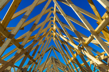 New residential construction home framing against a blue sky 