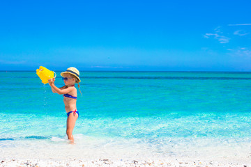 Fototapeta na wymiar Little girl having fun on tropical beach with turquoise ocean