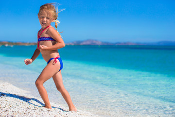 Little girl having fun enjoying vacation on tropical beach with