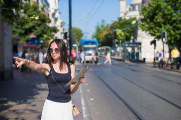 Fototapeta premium Young beautiful traveling woman with map in the city