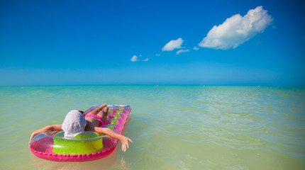 Fototapeta na wymiar Little girl having fun on tropical beach with turquoise ocean