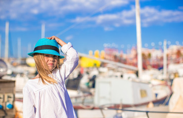 Cute little girl having fun in a port during summer vacation