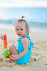Adorable little girl playing with beach toys during summer