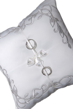 Wedding rings on pillow isolated on white background