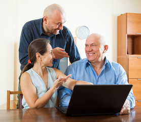 Two men and woman at laptop