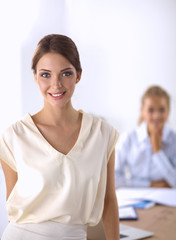 Fototapeta premium Attractive young businesswoman standing near desk in office