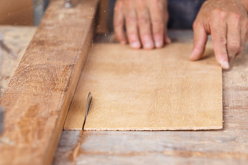 carpenter use saw cut wood for make new furniture