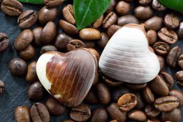 coffee beans and chocolate candies in a heart shape, close-up