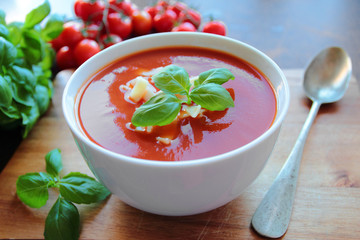 Bowl with tomato soup with macaroni and basil