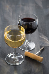 glass of white and red wine on a dark wooden background