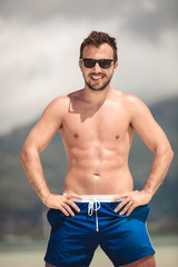 Obraz premium Sexy young man posing at the seaside