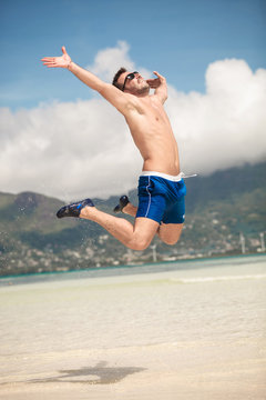 happy man jumping of joy on the beach