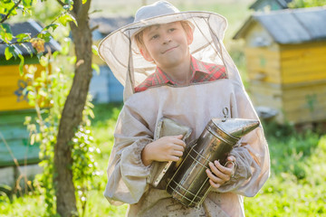 Young beekeeper using a smoker on bee yard
