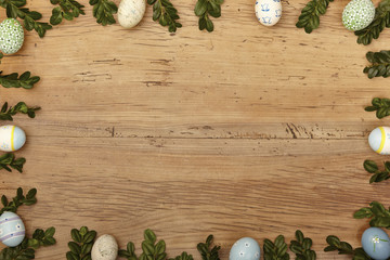 Zweige und Ostereier als Rahmen auf Holz, Textfreiraum