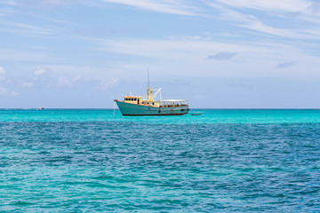 Obraz premium Yellow and White Fishing Boat in Aqua Water