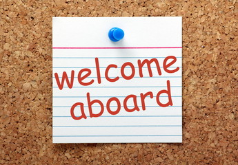 Welcome Aboard printed index card on a notice board